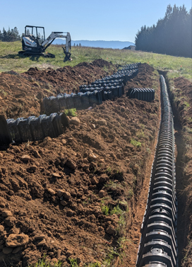 Drain field trench with piping laid on a hillside